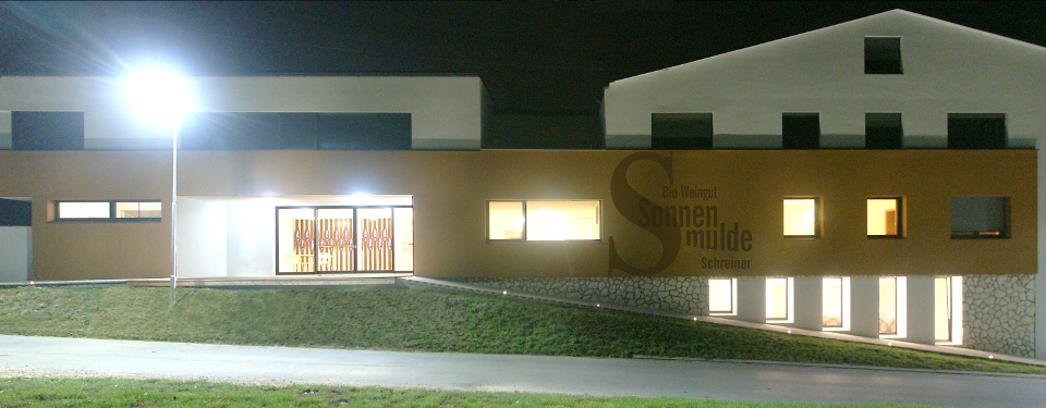 View towards the illuminated winery at night