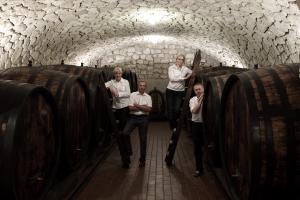 The Schreiner family, in part standing on ladders, between big wooden casks